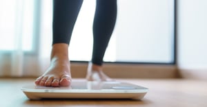 woman stepping onto a weight scale